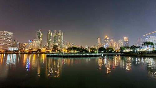 Illuminated buildings in city against sky at night