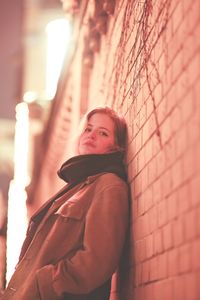 Portrait of woman standing against wall