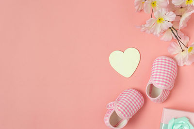 Close-up of heart shape with pink flower on table