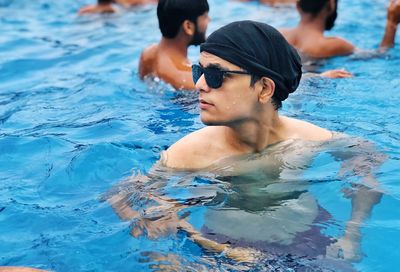 Shirtless young man swimming in pool