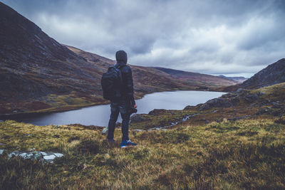 Man standing on mountain against sky