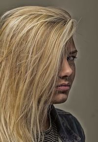 Close-up of young woman against gray background