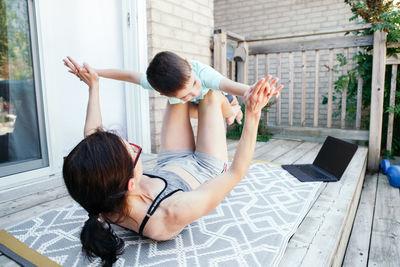 Family sport activity. caucasian mother with toddler son doing distant remote online fitness workout 