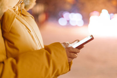 Midsection of woman using mobile phone