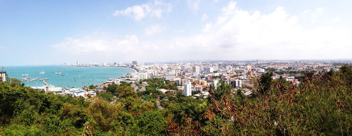 Panoramic view of sea and cityscape against sky