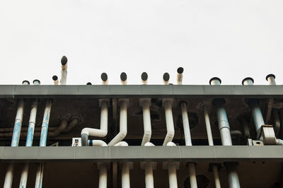 Low angle view of birds perching on building against sky