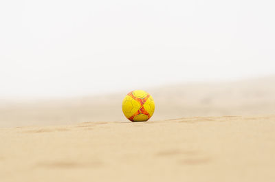 Close-up of yellow ball on beach