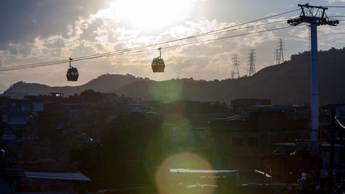 Overhead cable car and buildings against sky during sunset