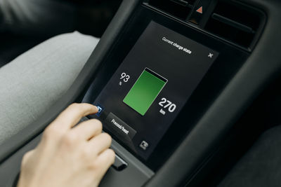 Man checking battery on screen while traveling in electric car