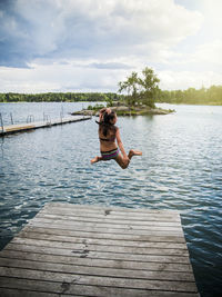 Girl jumping into lake