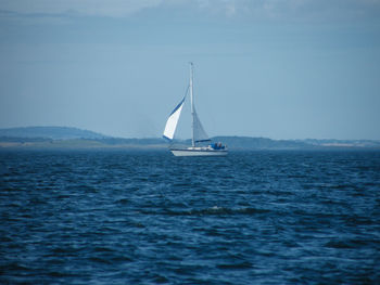 Sailboat sailing on sea against sky