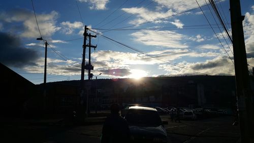 Low angle view of silhouette electricity pylon against sky during sunset