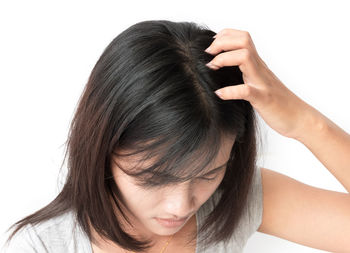 Close-up of woman with hands against white background