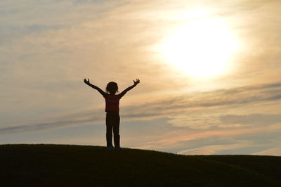 Rear view of silhouette woman standing against sky