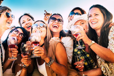 Group of cheerful friends enjoying drinks outdoors