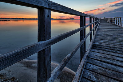 Pier over sea against sky during sunset