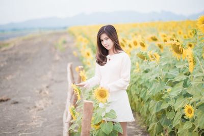 Portrait of a beautiful young woman standing on landscape