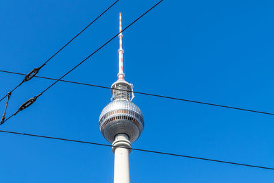 Low angle view of communications tower against blue sky