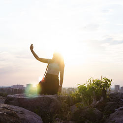 Rear view of man standing against sky during sunset