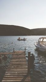 Pier over lake against clear sky