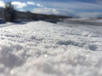 Surface level of frozen landscape against sky