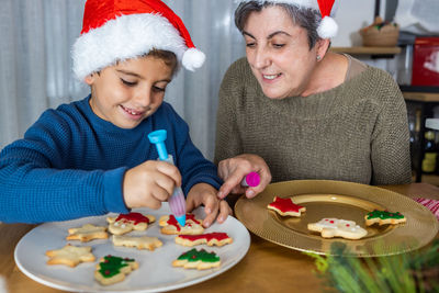 High angle view of grandmother and granddaughter preparing cookies at home