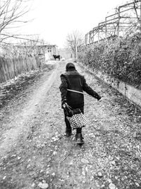 Rear view of woman walking on footpath