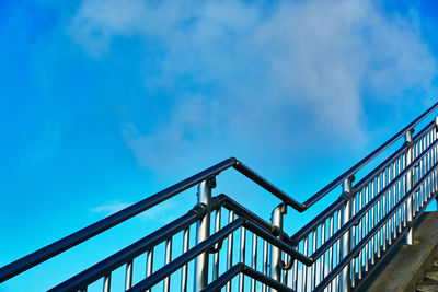 Low angle view of metal railing of staircase against sky