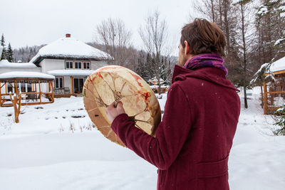 Woman standing on snow covered landscape during winter