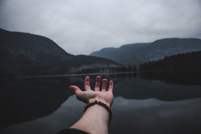 Low section of person on lake against mountain