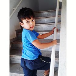 Portrait of cute boy climbing steps