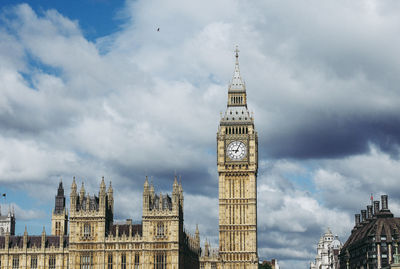 Buildings in city against cloudy sky