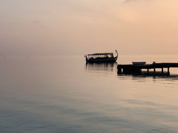 Lifeguard hut on sea against sky during sunset