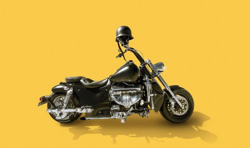 Close-up of motorcycle against yellow background