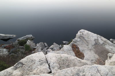 High angle view of rocks against calm lake