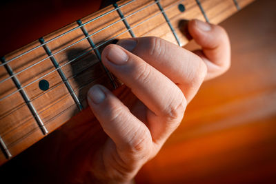 Midsection of man playing guitar