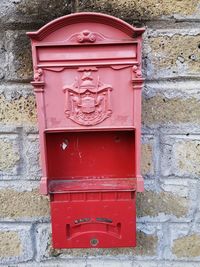 Close-up of red mailbox on wall