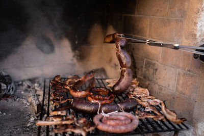 Unrecognizable man cooking pork meat on a firewood barbecue. close up.