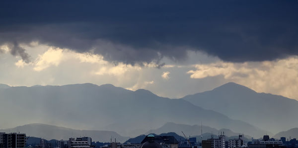 Cityscape against cloudy sky