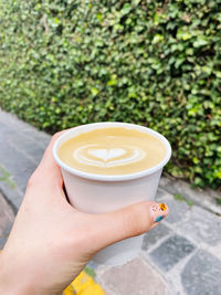 Cropped image of hand holding coffee cup