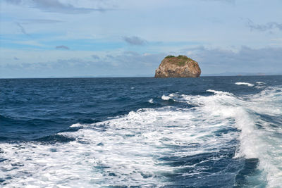 Scenic view of rocks in sea against sky