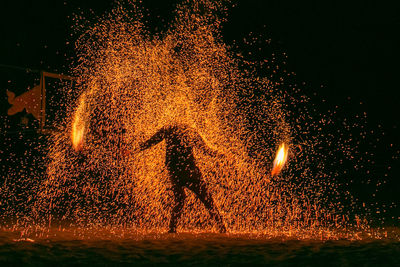 Firework display on illuminated field at night