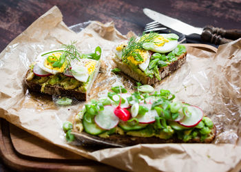 High angle view of open faced sandwiches on wax paper