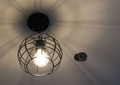 Low angle view of light bulb hanging from ceiling