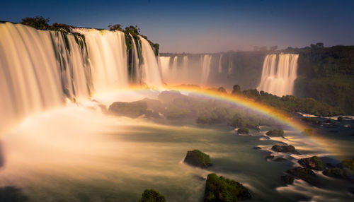 Scenic view of waterfall against sky