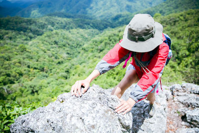 Side view of boy standing on rock