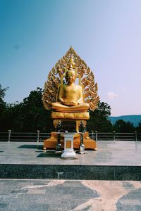 Statue of temple against building and sky