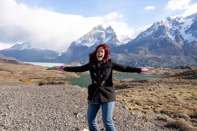 Full length of woman standing on mountain against sky