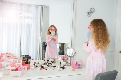 Rear view of girl playing with toys at home