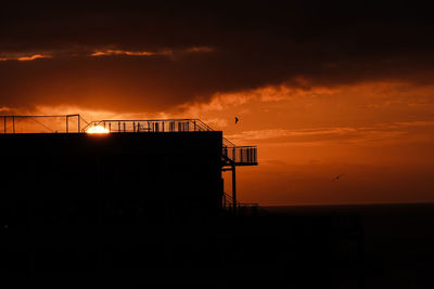 Low angle view of silhouette building against sky during sunset